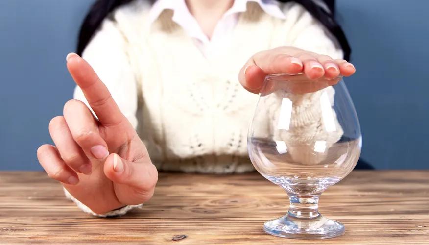 Person refusing alcohol by covering a glass