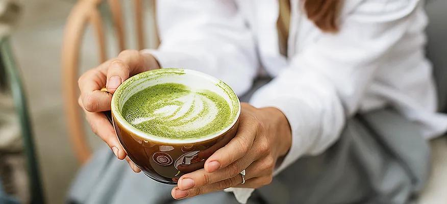 Cup of fresh matcha with matcha powder and bamboo whisk, traditional Japanese tea ceremony concept