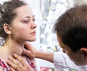 A woman affected by pain of thyroid